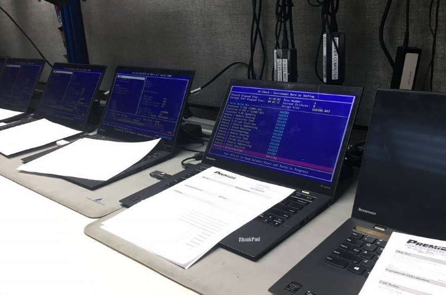 Image showing computers at Premier Computer Services, Inc. running diagnostics with reports on the keyboards